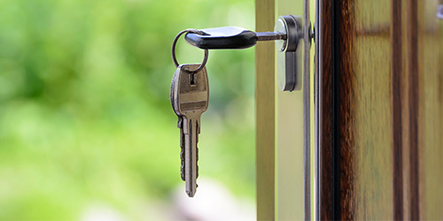 ein Schlüsselbund mit einem Schlüssel im Fensterschloss